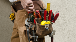 Eine volle Werkzeugtasche eines Handwerkers, befestigt an seinem Gürtel.